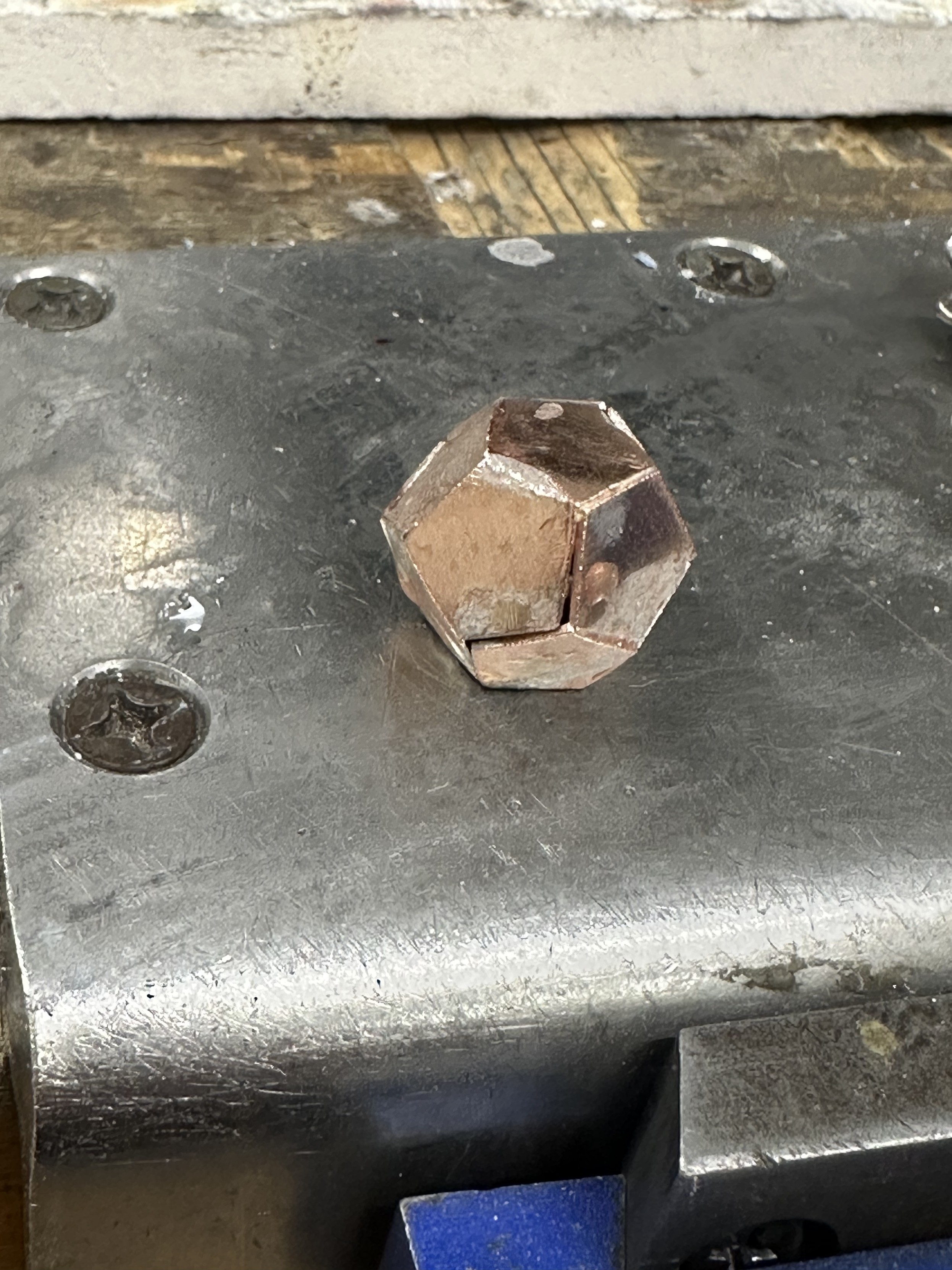 A small dodecahedron (“d12”) made of copper sheet cut into pentagons about 0.5” wide and then soldered with silver solder. The soldering is not very good: it ran all over the faces instead of staying in the joints, but I have learned some things since making it…